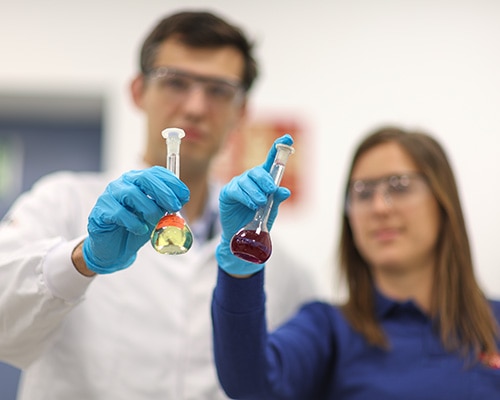 man and woman examine a samples in a lab