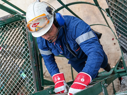 person at factory climbing ladder
